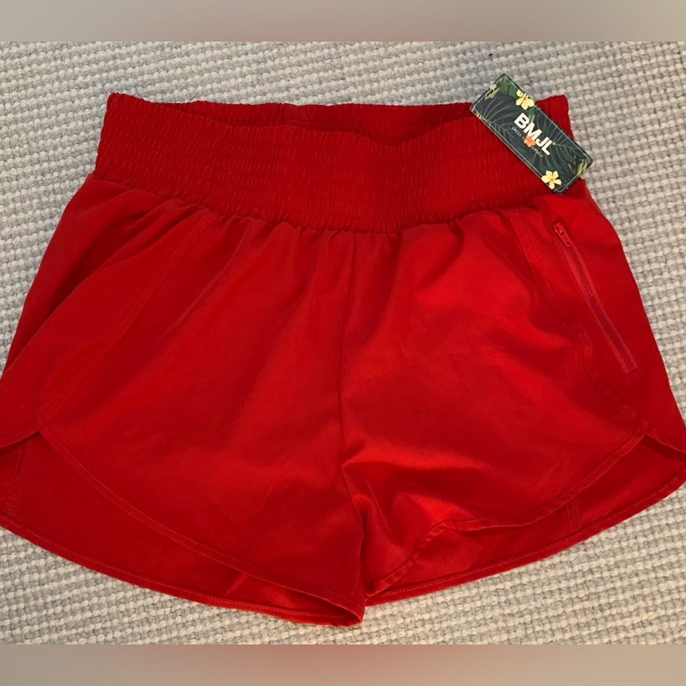 Red athletic shorts, lined, zipper pocket, size large.